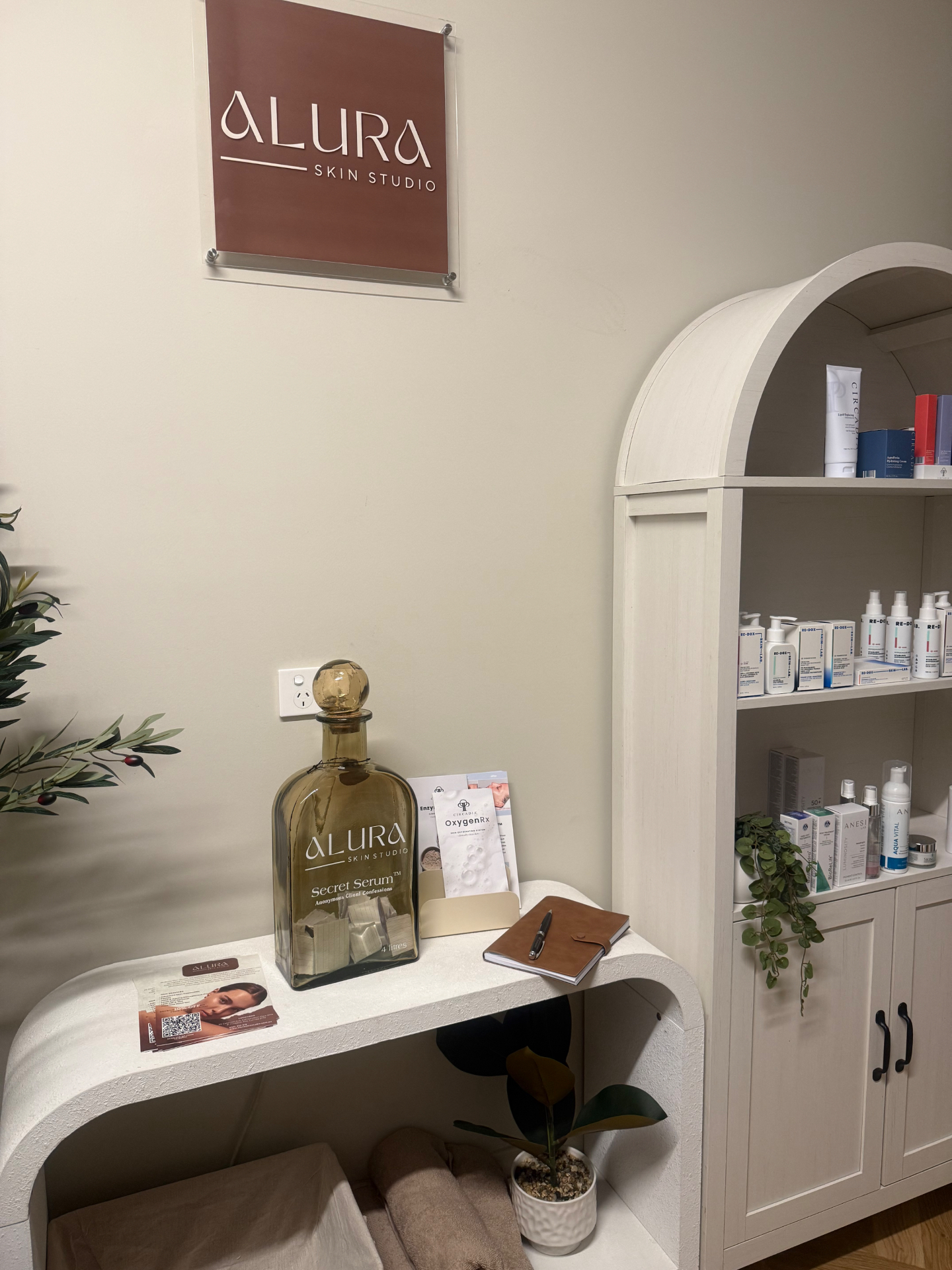 Reception area of Alura Skin Studio with signage and retail shelving
